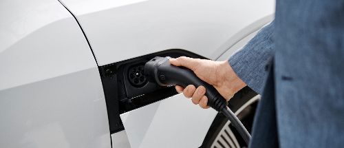 Nahaufnahme weißes Elektroauto, das geladen wird