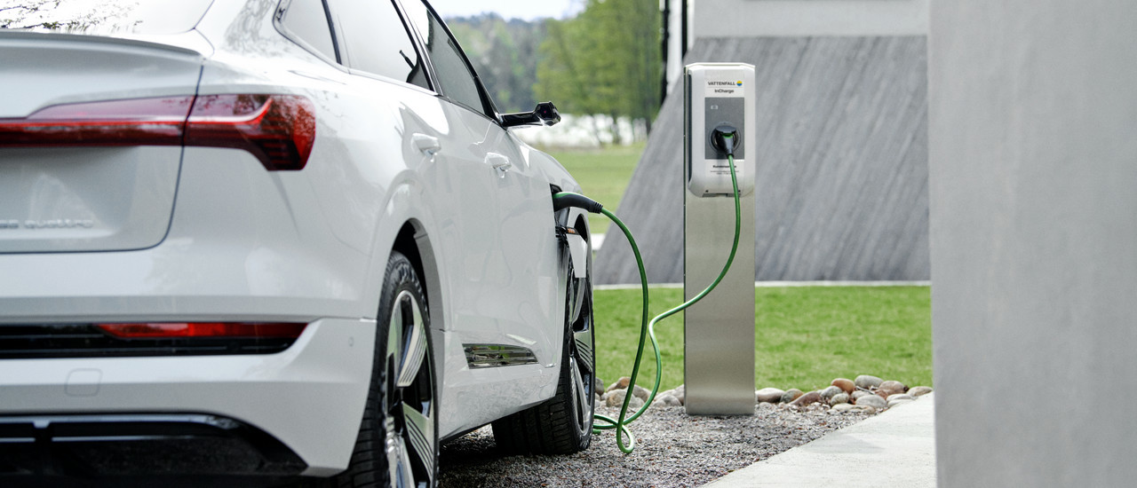Weißes E-Auto lädt an Ladestation