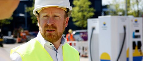 Mann steht neben Ladesäule von Vattenfall